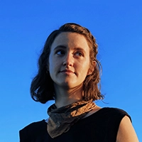 A headshot of Brittany pictured against a blue sky.